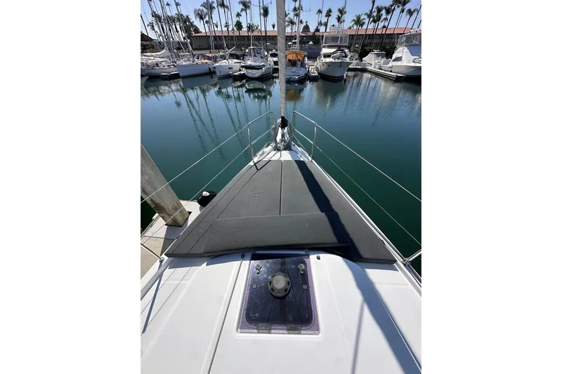 Best Day Ever Yacht Photos Pics 2022 Jeanneau Sun Odyssey 410 sailboat bow view in marina with calm waters.