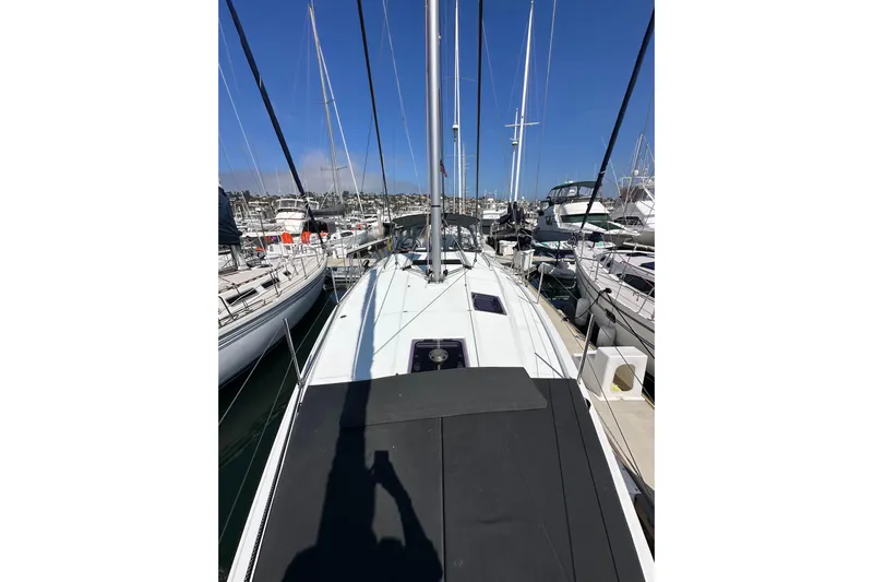 Best Day Ever Yacht Photos Pics 2022 Jeanneau Sun Odyssey 410 sailboat docked at a marina, surrounded by other boats.