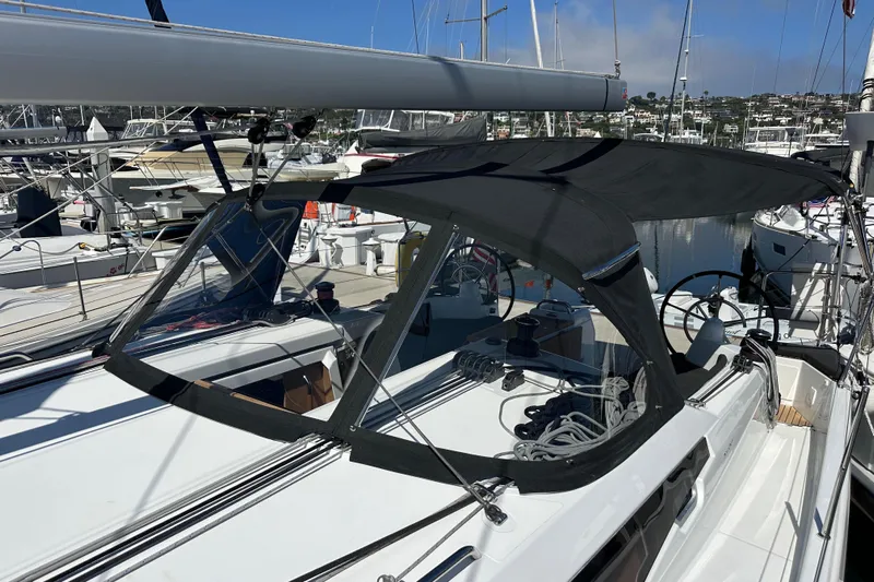 Best Day Ever Yacht Photos Pics 2022 Jeanneau Sun Odyssey 410 sailboat docked at marina, featuring sleek design and black canopy.