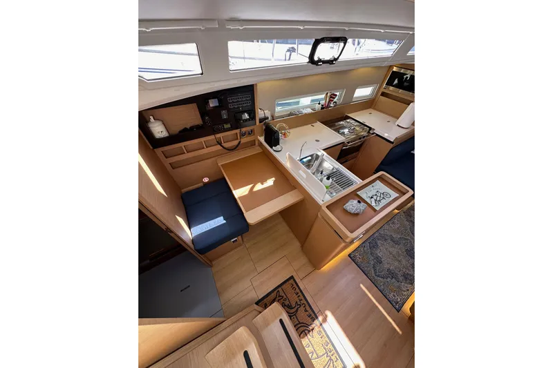 Best Day Ever Yacht Photos Pics Interior of 2022 Jeanneau Sun Odyssey 410 yacht, featuring modern kitchen and seating area.