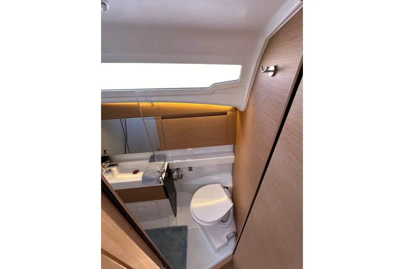 Best Day Ever Yacht Photos Pics Modern bathroom interior of 2022 Jeanneau Sun Odyssey 410 yacht, featuring sleek design and wood accents.