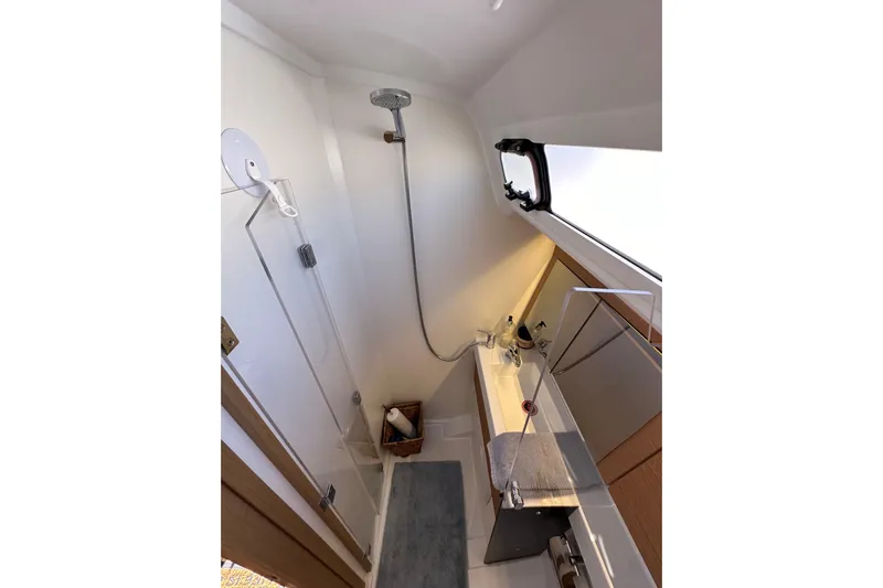 Best Day Ever Yacht Photos Pics Modern bathroom interior of 2022 Jeanneau Sun Odyssey 410 yacht, featuring shower and sink.