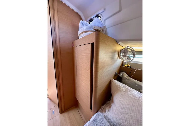 Best Day Ever Yacht Photos Pics Interior cabin of 2022 Jeanneau Sun Odyssey 410 yacht, featuring wooden paneling and cozy bedding.