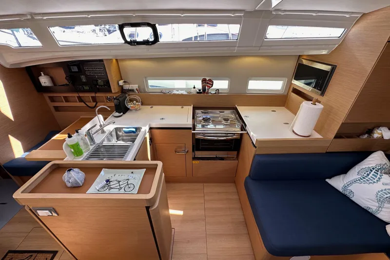 Best Day Ever Yacht Photos Pics Interior of 2022 Jeanneau Sun Odyssey 410 yacht, featuring modern kitchen and seating area.