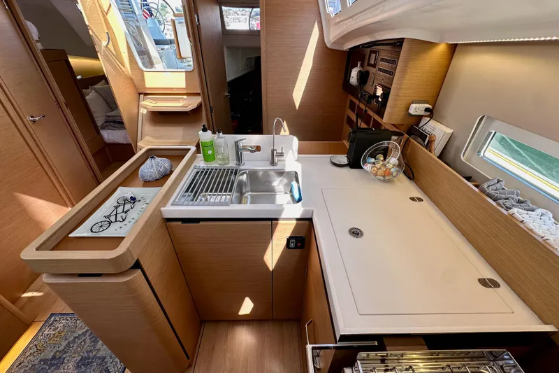 Best Day Ever Yacht Photos Pics Modern kitchen interior of 2022 Jeanneau Sun Odyssey 410 yacht, featuring sleek design and amenities.