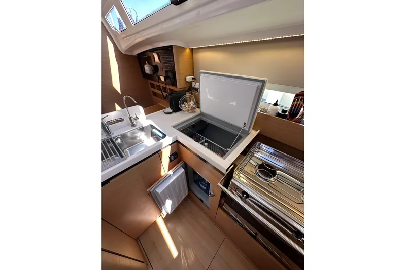Best Day Ever Yacht Photos Pics Modern kitchen interior of 2022 Jeanneau Sun Odyssey 410 yacht, featuring sleek appliances.