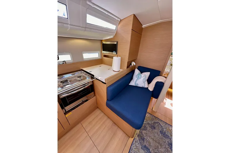 Best Day Ever Yacht Photos Pics Interior of 2022 Jeanneau Sun Odyssey 410 yacht with modern kitchen and cozy seating area.