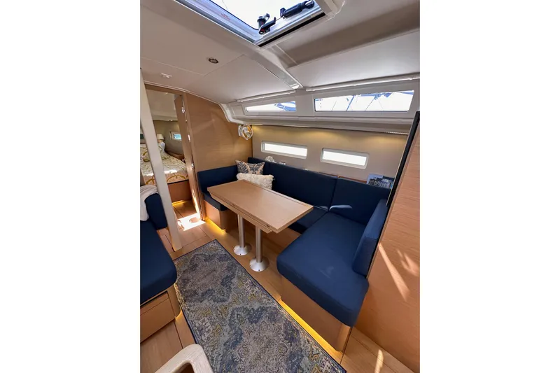 Best Day Ever Yacht Photos Pics Interior of 2022 Jeanneau Sun Odyssey 410 sailboat with cozy seating and wooden table.