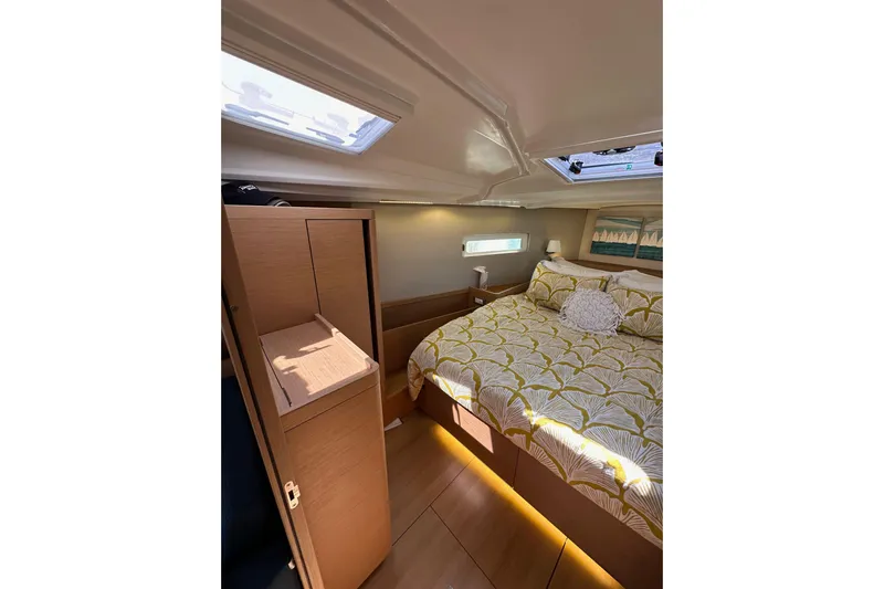 Best Day Ever Yacht Photos Pics Luxurious interior cabin of 2022 Jeanneau Sun Odyssey 410 sailboat with cozy bedding.