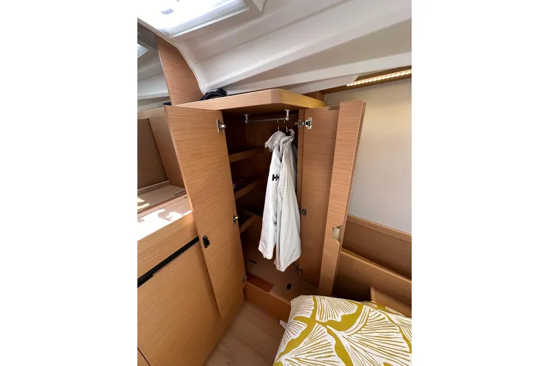 Best Day Ever Yacht Photos Pics Interior of 2022 Jeanneau Sun Odyssey 410 showing wooden wardrobe and cozy bedding.
