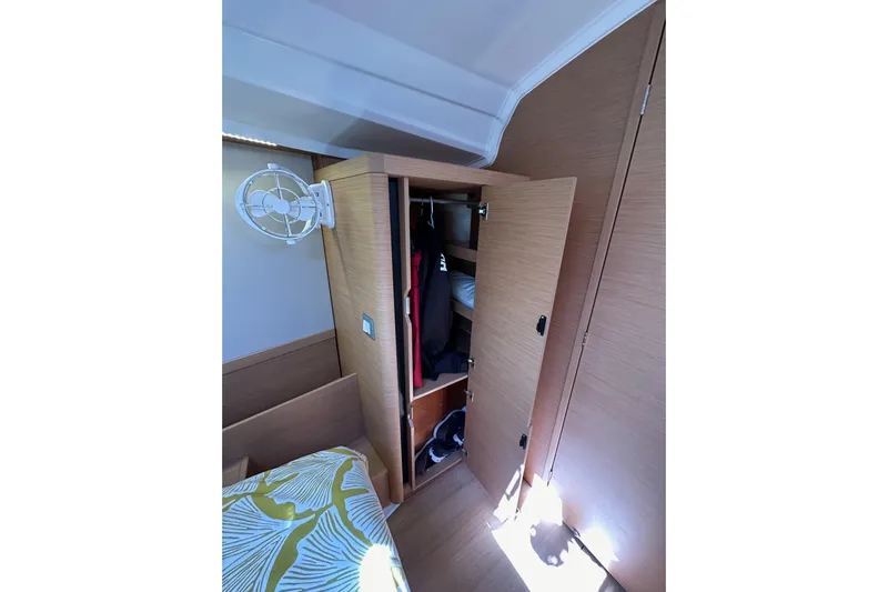 Best Day Ever Yacht Photos Pics Interior of 2022 Jeanneau Sun Odyssey 410 showing a wooden wardrobe and fan.