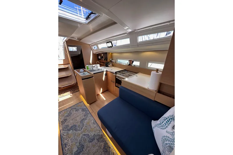 Best Day Ever Yacht Photos Pics Interior of 2022 Jeanneau Sun Odyssey 410 yacht, featuring modern kitchen and seating area.