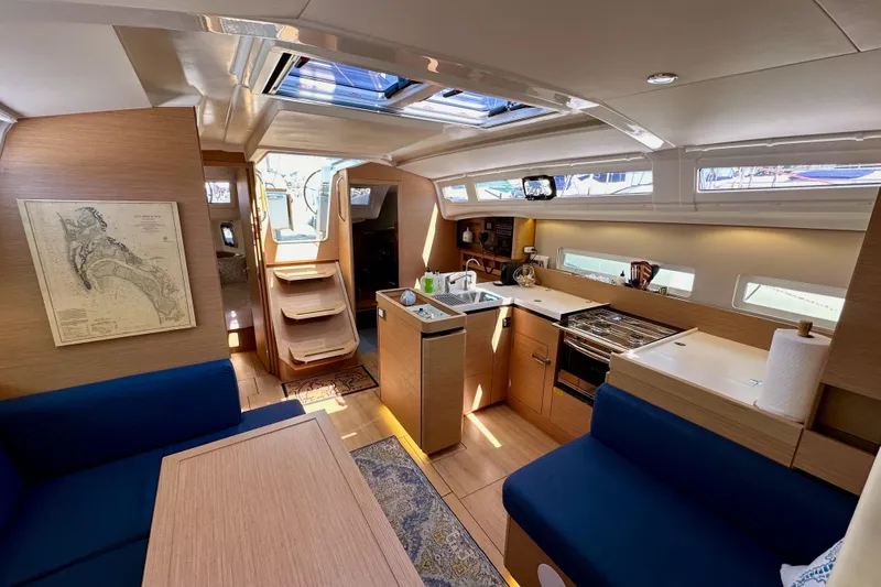 Best Day Ever Yacht Photos Pics Interior of 2022 Jeanneau Sun Odyssey 410 yacht, featuring modern kitchen and seating area.