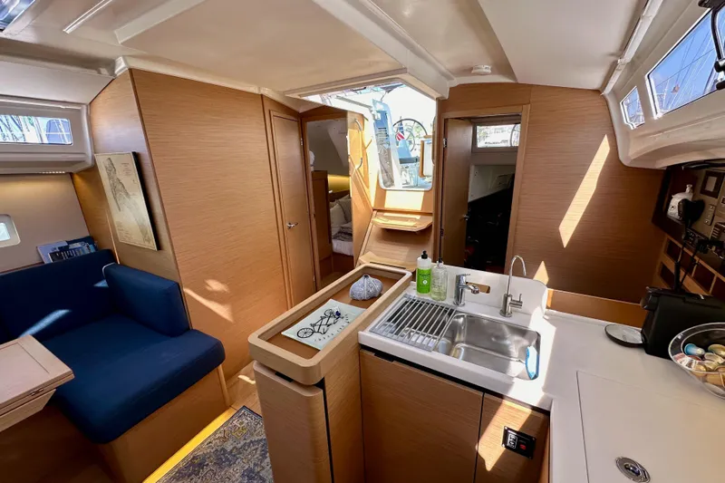 Best Day Ever Yacht Photos Pics Interior of 2022 Jeanneau Sun Odyssey 410 sailboat, featuring modern kitchen and seating area.