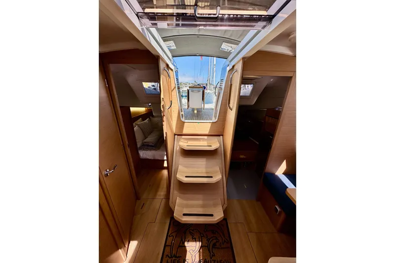 Best Day Ever Yacht Photos Pics Interior view of 2022 Jeanneau Sun Odyssey 410 sailboat, featuring wooden steps and cozy cabins.