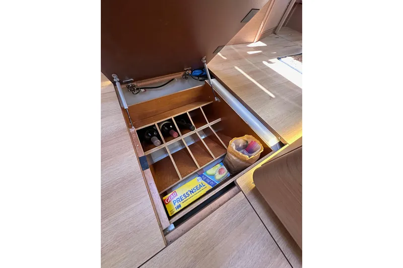 Best Day Ever Yacht Photos Pics Underfloor storage on 2022 Jeanneau Sun Odyssey 410 yacht with wine rack and supplies.