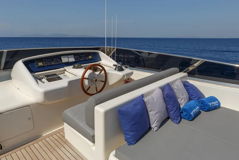  Yacht Photos Pics Luxurious 2003 Canados 86 yacht deck with seating, cushions, and steering wheel, overlooking the sea.