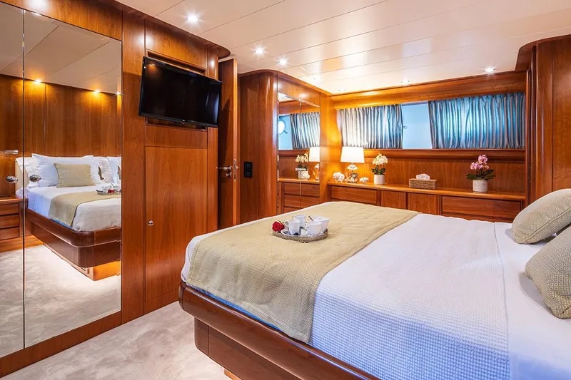  Yacht Photos Pics Luxurious bedroom interior on 2003 Canados 86 yacht, featuring elegant wood paneling and modern amenities.