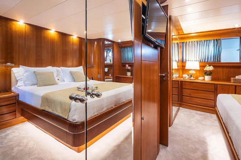  Yacht Photos Pics Luxurious bedroom interior on a 2003 Canados 86 yacht, featuring elegant wood finishes.