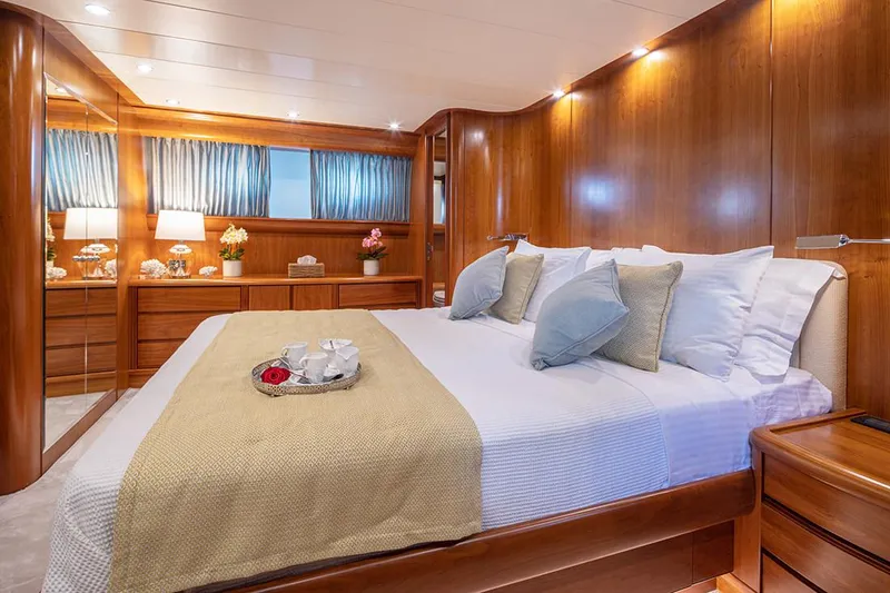  Yacht Photos Pics Luxurious bedroom interior on 2003 Canados 86 yacht with elegant wood paneling and cozy bedding.