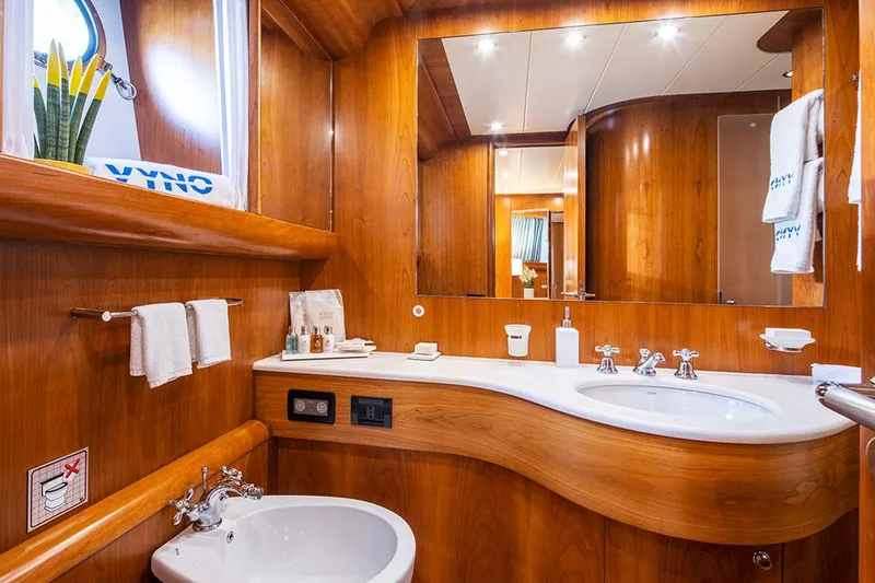  Yacht Photos Pics Luxurious wooden bathroom interior on a 2003 Canados 86 yacht, featuring elegant fixtures.