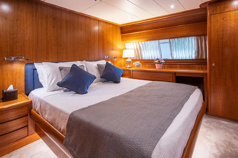  Yacht Photos Pics Luxurious bedroom interior of 2003 Canados 86 yacht with wooden furnishings and cozy bedding.