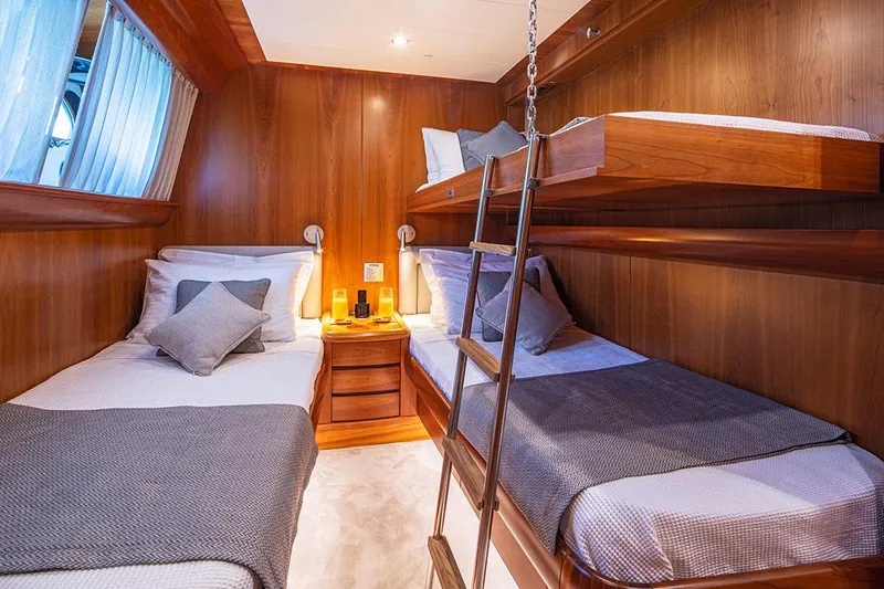  Yacht Photos Pics Luxurious cabin interior of 2003 Canados 86 yacht with wooden bunk beds and cozy decor.
