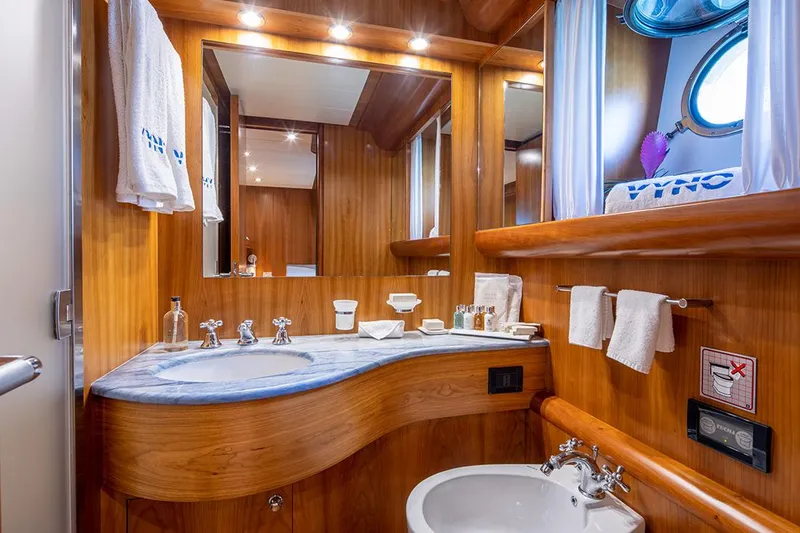  Yacht Photos Pics Luxurious wooden bathroom interior on a 2003 Canados 86 yacht, featuring elegant fixtures and lighting.