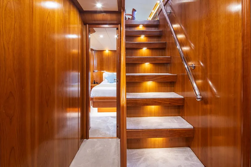  Yacht Photos Pics Luxurious wooden interior of 2003 Canados 86 yacht with illuminated staircase and cozy bedroom.