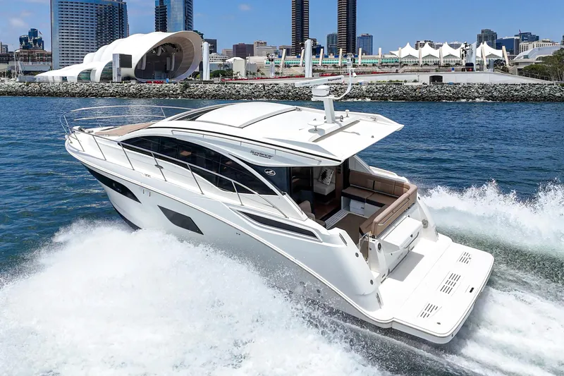  Yacht Photos Pics 2017 Sea Ray Sundancer 400 yacht cruising near a modern cityscape.