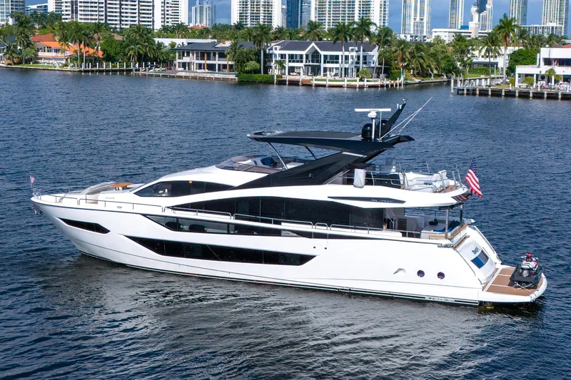 Ramaya 4 Yacht Photos Pics 2023 Sunseeker 88 Yacht cruising on a scenic waterfront with luxury homes.