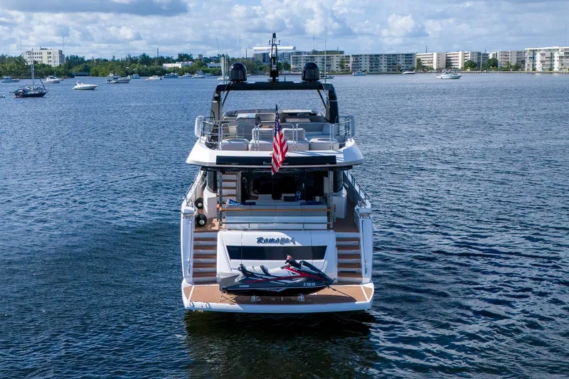 Ramaya 4 Yacht Photos Pics 2023 Sunseeker 88 Yacht on water, rear view with jet ski and American flag.