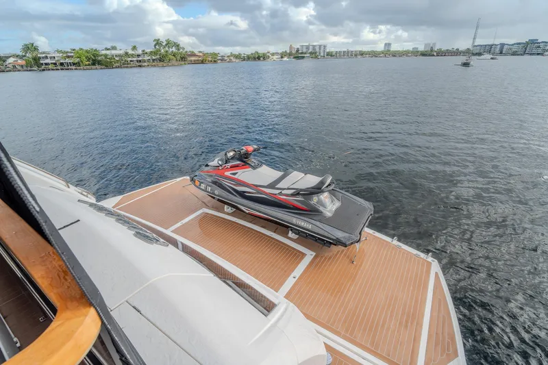 Ramaya 4 Yacht Photos Pics 2023 Sunseeker 88 Yacht with jet ski on deck, overlooking calm waters.