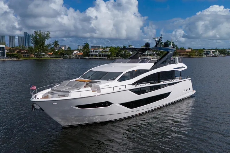 Ramaya 4 Yacht Photos Pics 2023 Sunseeker 88 Yacht cruising on a scenic waterway under a partly cloudy sky.