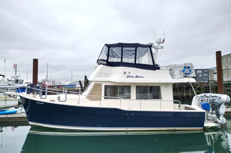 Hula Moon Yacht Photos Pics 2006 Mainship 34 Trawler docked in a marina, featuring a blue hull and enclosed flybridge.