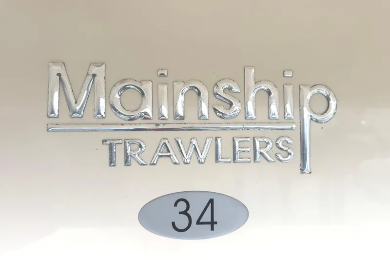 Hula Moon Yacht Photos Pics Mainship 34 Trawler 2006 logo with metallic lettering on a light background.