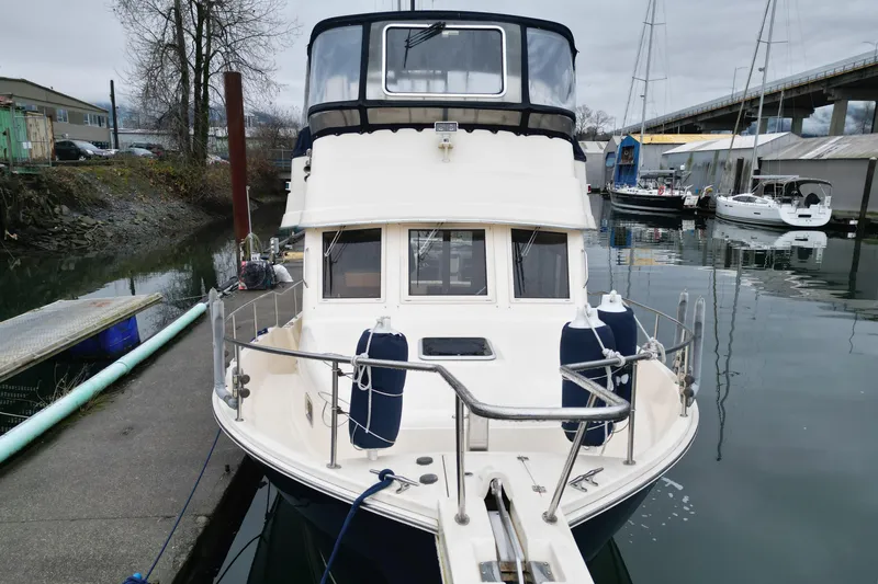 Hula Moon Yacht Photos Pics 2006 Mainship 34 Trawler docked at a marina, front view.