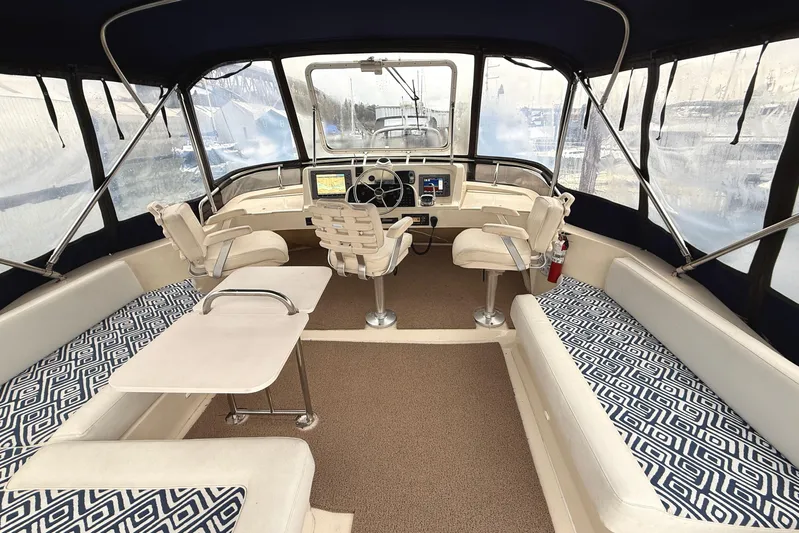 Hula Moon Yacht Photos Pics 2006 Mainship 34 Trawler interior with helm, seating, and patterned cushions.