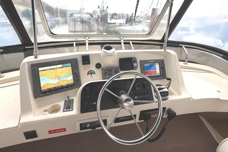 Hula Moon Yacht Photos Pics Helm of 2006 Mainship 34 Trawler with navigation equipment and steering wheel.