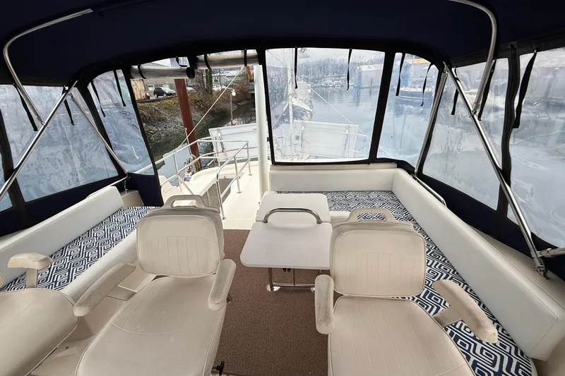 Hula Moon Yacht Photos Pics Interior view of 2006 Mainship 34 Trawler with seating and table setup.