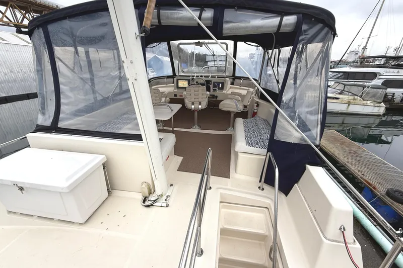 Hula Moon Yacht Photos Pics 2006 Mainship 34 Trawler interior with helm, seating, and marina view.