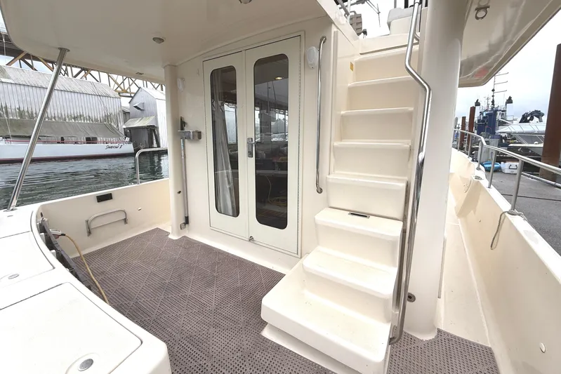 Hula Moon Yacht Photos Pics 2006 Mainship 34 Trawler boat deck with stairs and glass doors, docked at marina.