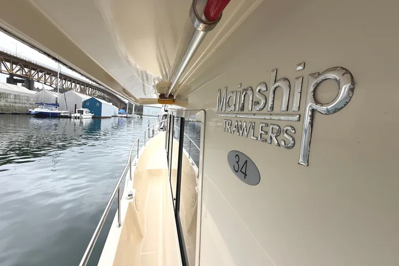 Hula Moon Yacht Photos Pics 2006 Mainship 34 Trawler docked near a bridge and marina.