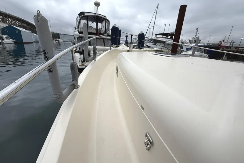 Hula Moon Yacht Photos Pics 2006 Mainship 34 Trawler docked at marina on a cloudy day.