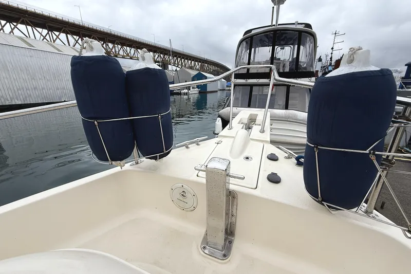 Hula Moon Yacht Photos Pics 2006 Mainship 34 Trawler docked, featuring fenders and a view of the marina.