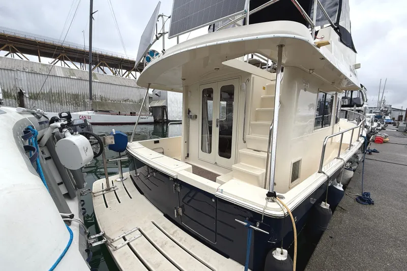 Hula Moon Yacht Photos Pics 2006 Mainship 34 Trawler docked, showcasing rear deck and entryway.