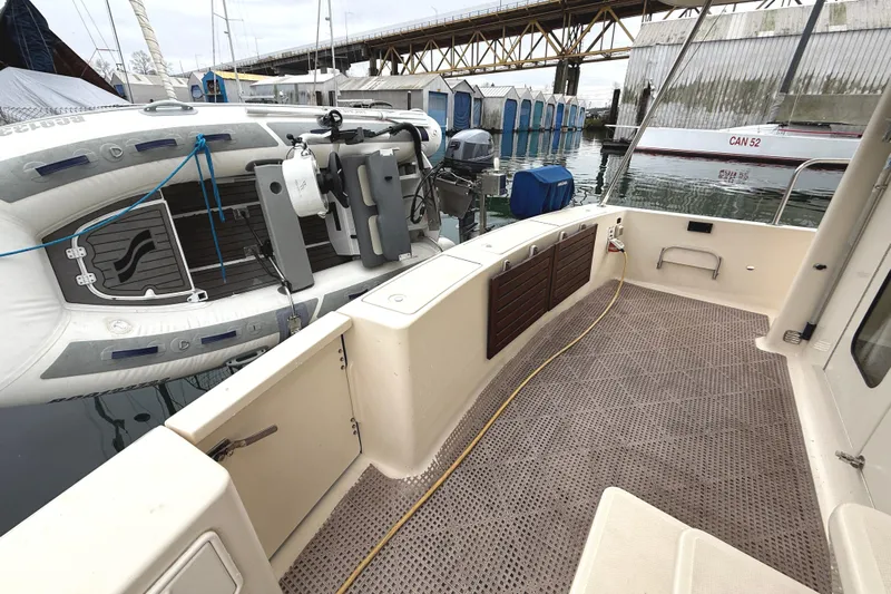 Hula Moon Yacht Photos Pics 2006 Mainship 34 Trawler deck with inflatable boat and marina view.