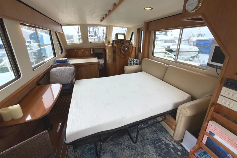 Hula Moon Yacht Photos Pics Interior of 2006 Mainship 34 Trawler with convertible sofa bed and helm station.