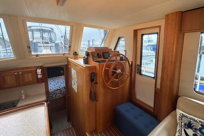 Hula Moon Yacht Photos Pics 2006 Mainship 34 Trawler interior with helm, wooden accents, and marina view.