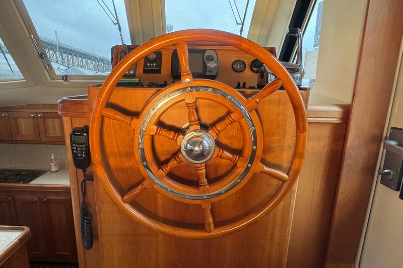 Hula Moon Yacht Photos Pics Wooden helm of 2006 Mainship 34 Trawler, featuring classic design and navigation instruments.